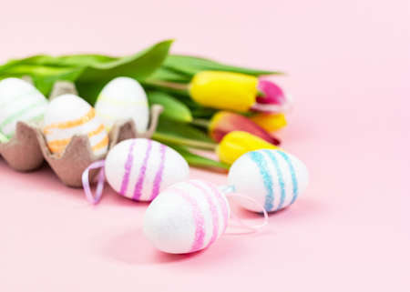 Easter painted eggs with tulips on a pink background. Copy space. Easter celebration conceptの写真素材