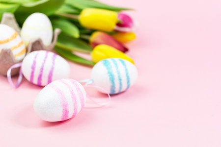 Easter painted eggs with tulips on a pink background. Copy space. Easter celebration conceptの写真素材