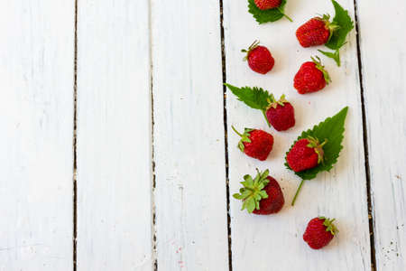 Ripe red strawberry lies in a pattern like a frame on a wooden white background. Copy space. View from aboveの写真素材