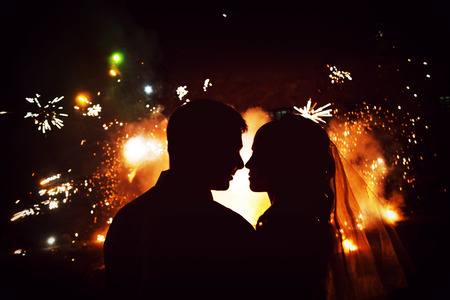 silhouette of couple on the background of fireworksの写真素材