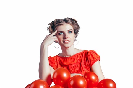 She thought and looking for solutions on a white background. The red dress with red balls.の写真素材