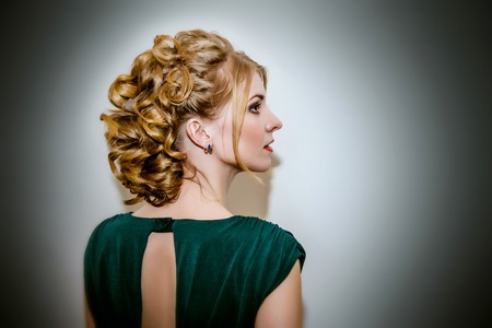 Beautiful girl in profile with lush hair in green dress.の写真素材