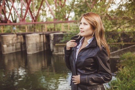 girl Asian girl in a leather jacket stands on the natureの写真素材