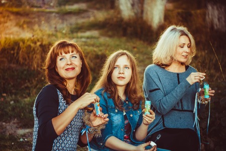 mother and daughter sitting in nature and watching the skyの写真素材
