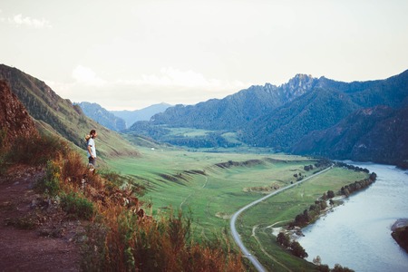 The young man sat looking at the view from the mountain