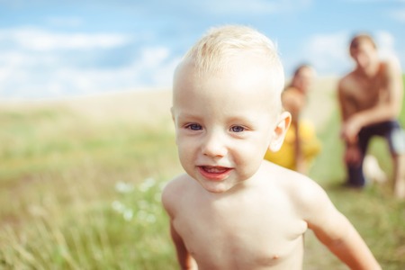 a boy runs across the field naked in diapersの写真素材