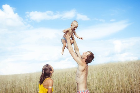 Father playing with young son lifting his hands upの写真素材