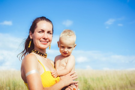 Cute caucasian mother holding her newborn baby outdoor in the woodsの写真素材