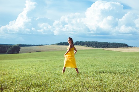 Beautiful Young Woman Outdoors. Enjoy Nature. Healthy Smiling Girl in Green Grass.の写真素材