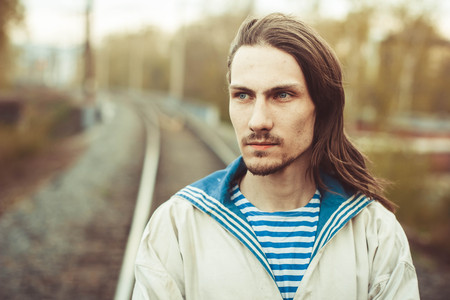 Guy portrait on a river dock. Handsome guy in sailor shirt.の写真素材