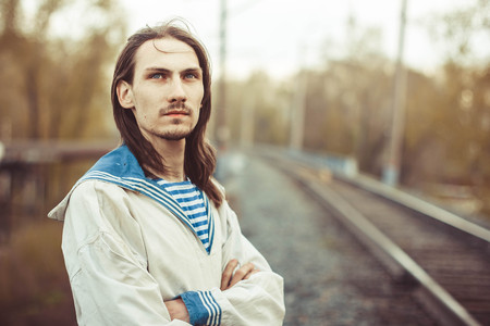 Guy portrait on a river dock. Handsome guy in sailor shirt.の写真素材