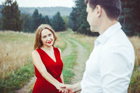 A nice couple in blue jeans and white t-shirts looking at each other happily standing back toの写真素材