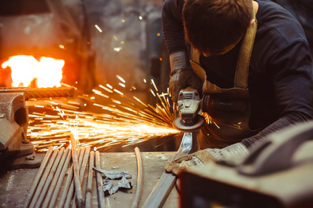 Worker cutting metal with grinder. Sparks while grinding ironの写真素材