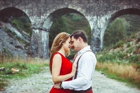 Lovers are standing at the bridge looking at each other