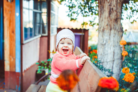 Little girl on a country plot, on a benchの写真素材