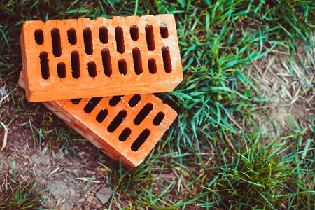 bricks lying on the green grass for constructionの写真素材