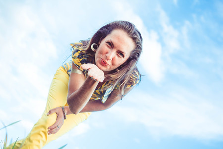 A woman bends over the camera and sends an air kissの写真素材