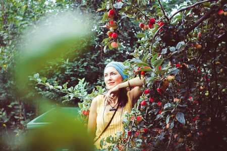 young girl is picking red currant in the fieldの写真素材
