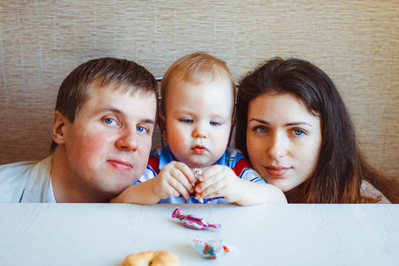 baby reaching shiny foil wrapped hard candyの写真素材