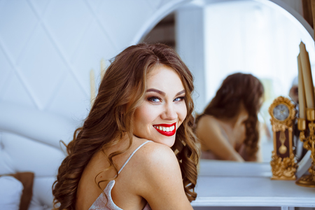 Young woman at home sitting on modern chairの写真素材