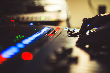 The hands of the sound engineer on the mixing consoleの写真素材