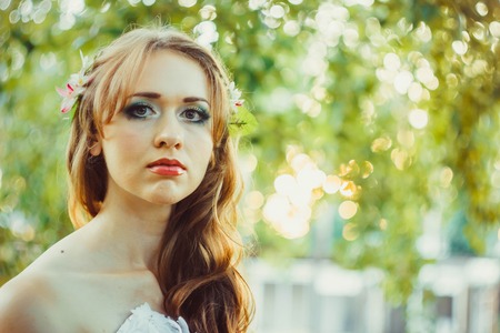 beautiful girl in the woods in a white dress with headscarfの写真素材