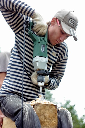 Russia, Siberiya - 1.09.2013: Construction worker framing the roof of a country house with help of a craneのeditorial素材