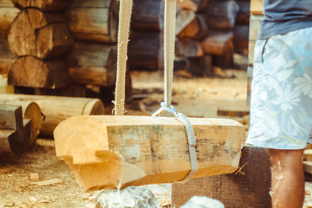 Workers raise the log with a craneの写真素材