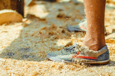 Worker standing in wood sawdust - background or texture