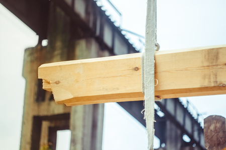 Workers raise the log with a craneの写真素材