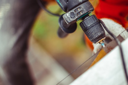 worker tightening the screws with a screwdriver on the front of the building