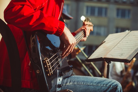Novokuzneck, Russia - 13.08.2017: the bass guitarist plays in the band on the street in the city of...