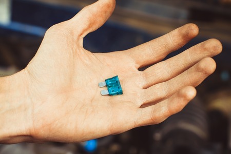 automotive fuse holding a mechanic on the carの写真素材