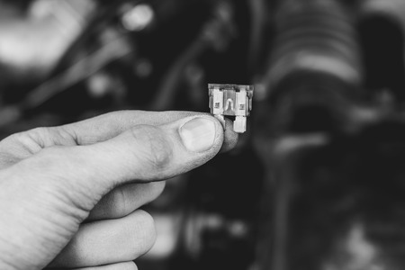 automotive fuse holding a mechanic on the carの写真素材