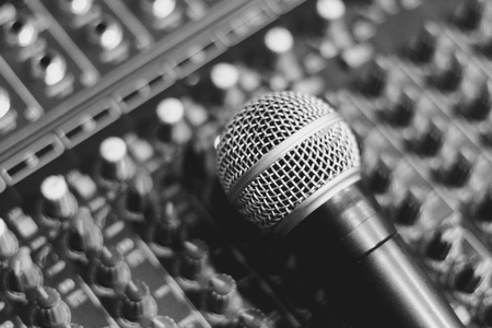 the microphone rests on an audio mixerの写真素材