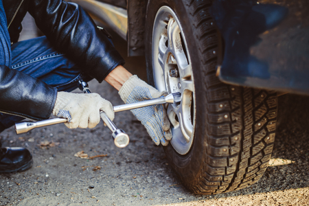 Change a flat car tire on road with Tire maintenance, damaged car tyreの写真素材
