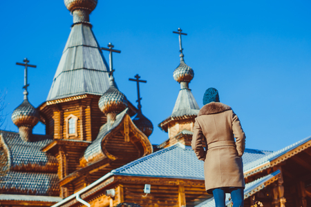 a woman looks at a wooden Church in Russiaの写真素材
