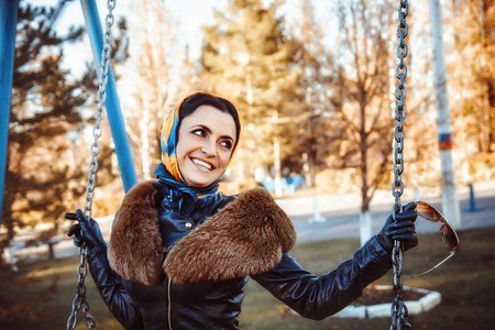happy woman on a swing in autumnの写真素材