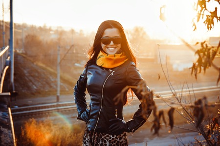 Closeup portrait of a beautiful student in the autumn Park, stylish women's hat with scarf and glassesの写真素材