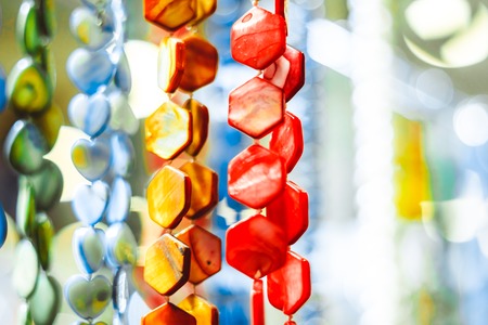 Colorful bijouterie and necklaces with beads hanging for sale in a shopの写真素材