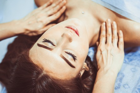 Spa. Brunette woman enjoying the anti-aging facial massageの写真素材