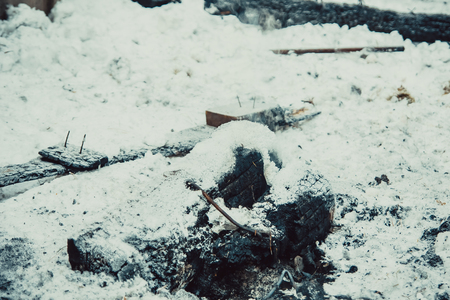 charred embers, covered with hoarfrost lie on the snowの写真素材