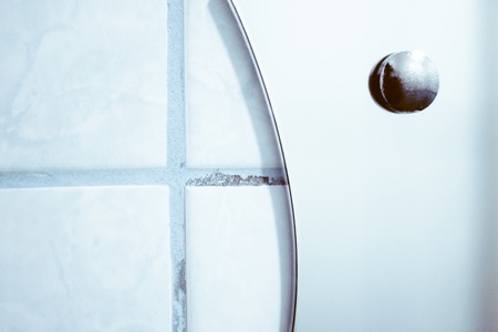 tiled wall and the edge of the mirror in the bathroomの写真素材