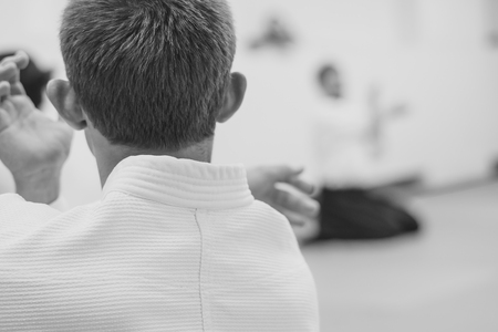 Young sporty man in kimono on light backgroundの写真素材