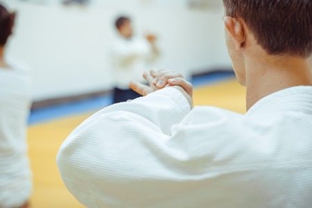 Young sporty man in kimono on light background