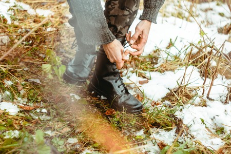 Tying shoes on the field standing in the woods on the autumn grassの写真素材