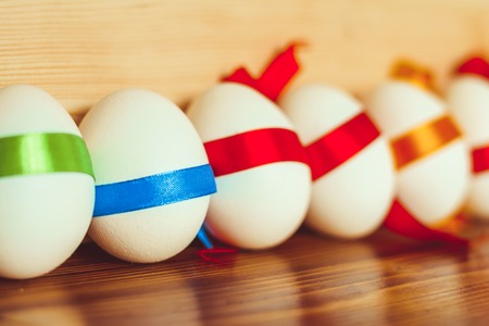 Colorful Easter eggs close-up tied with ribbonsの写真素材