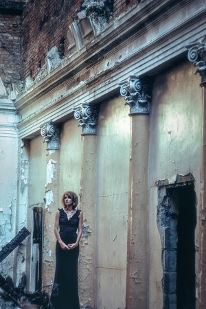 The old door is a girl in a black dress.の写真素材