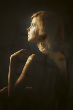 Pensive Woman Calmly Sitting Near Window Shades.の写真素材