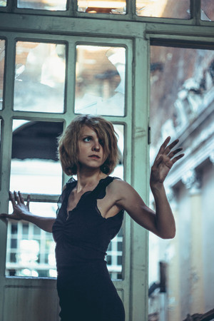 The old door is a girl in a black dress.の写真素材